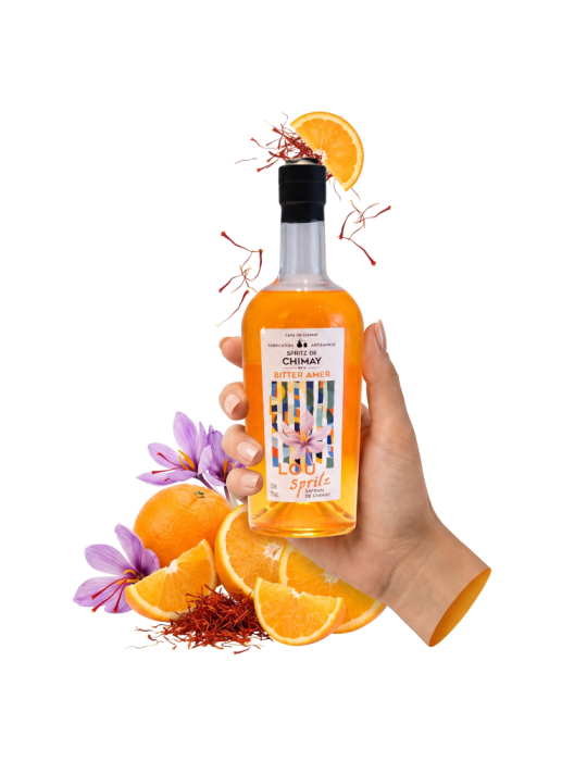 Bouteille de Lou Spritz de la Cave de Chimay, bitter amer artisanal à l'orange et au safran local, tenue en main. Bouteille de Lou Spritz de la Cave de Chimay, bitter amer artisanal à l'orange et au safran local, tenue en main.